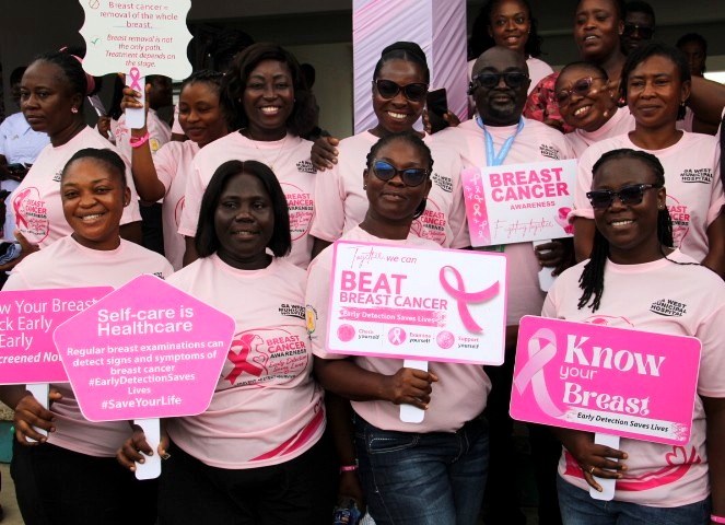 Hospital staff holding breast cancer awareness signs