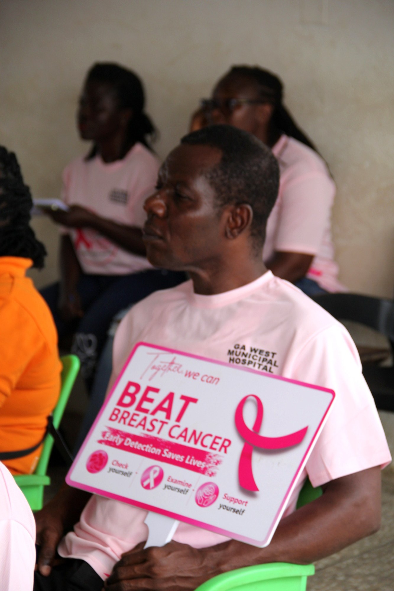 Participant holding a Beat Breast Cancer awareness placard