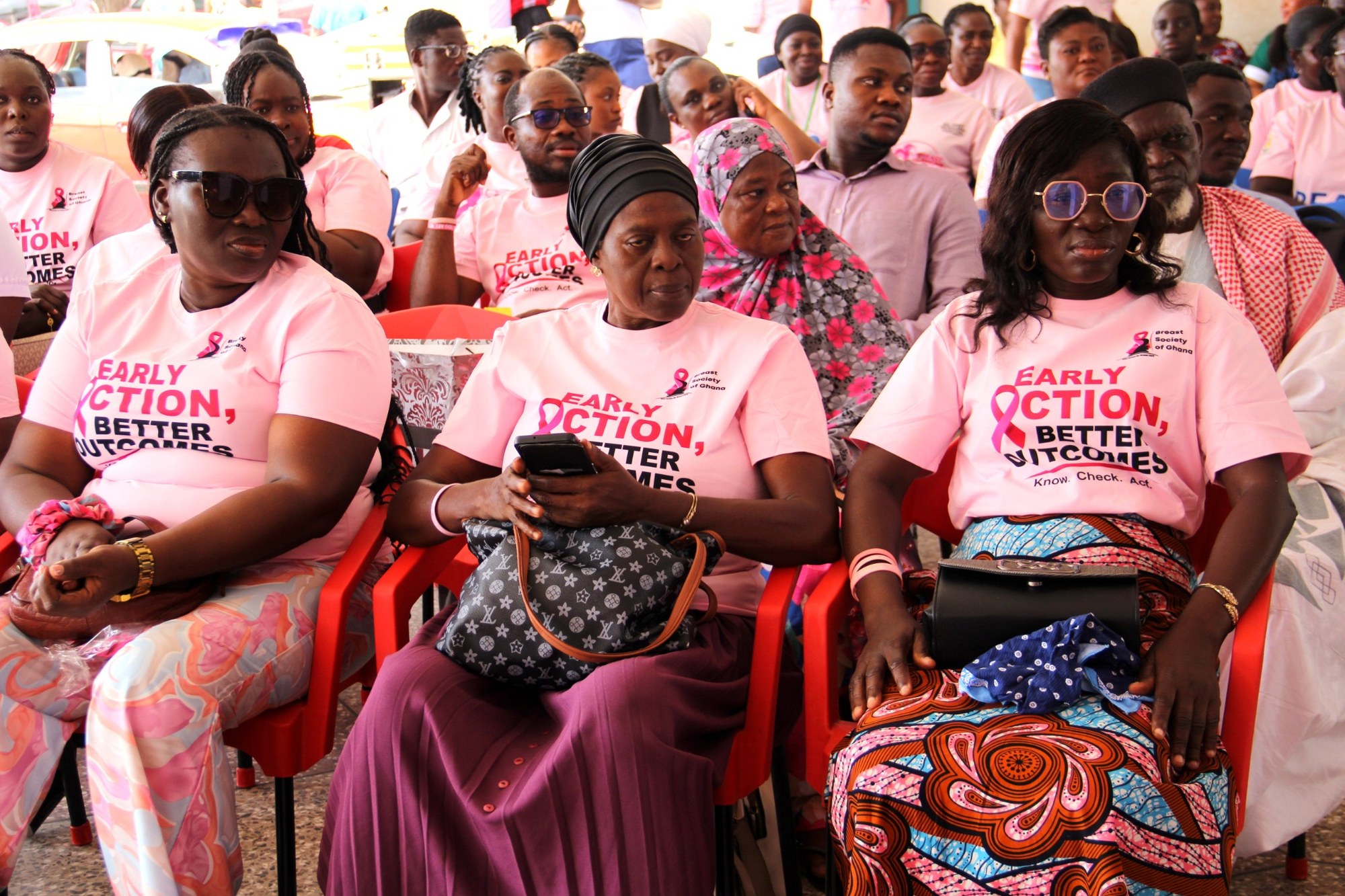 Audience members wearing pink early action better outcomes shirts